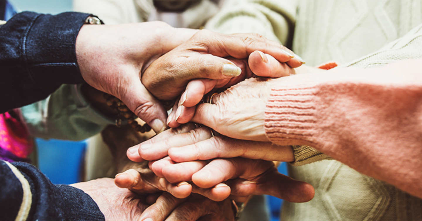 group of people holding hands in a circle