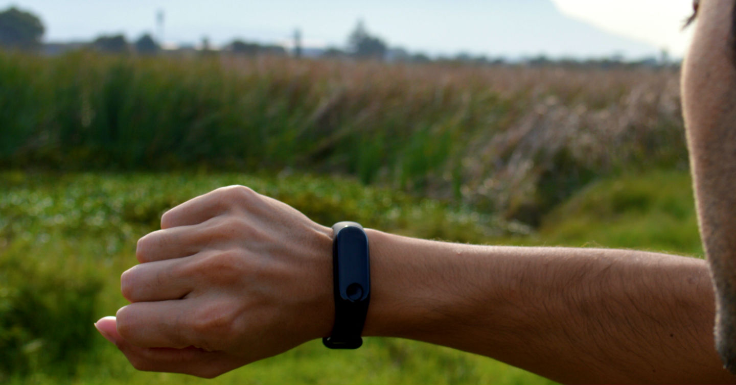 person checking fitness tracker fitbit smartwatch on run