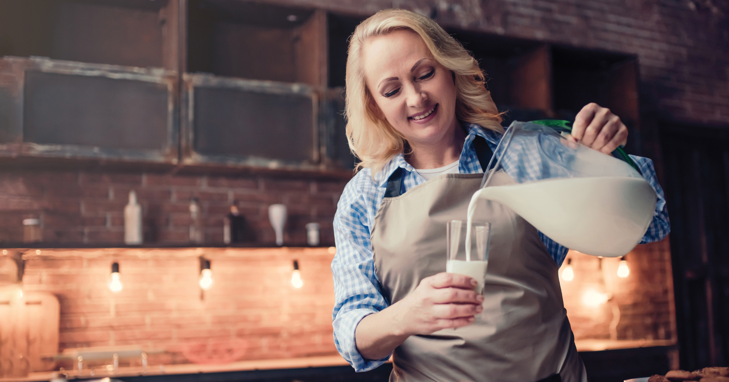a woman pouring a glass of milk for calcium to help with osteoporosis