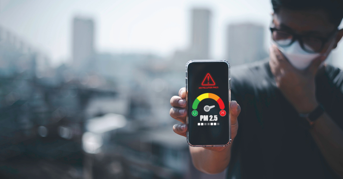 person holding a smarthphone that shows the current air quality