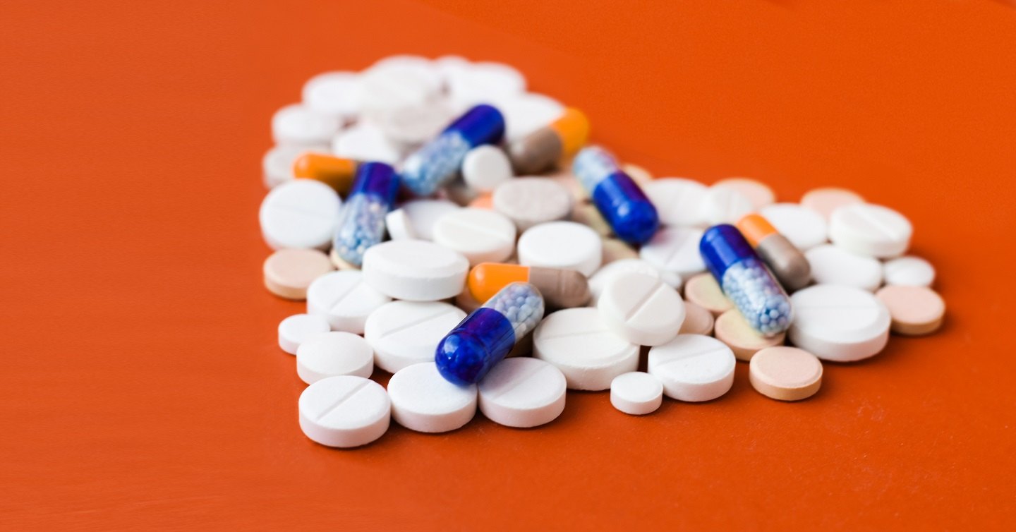 pills forming a heart on an orange table