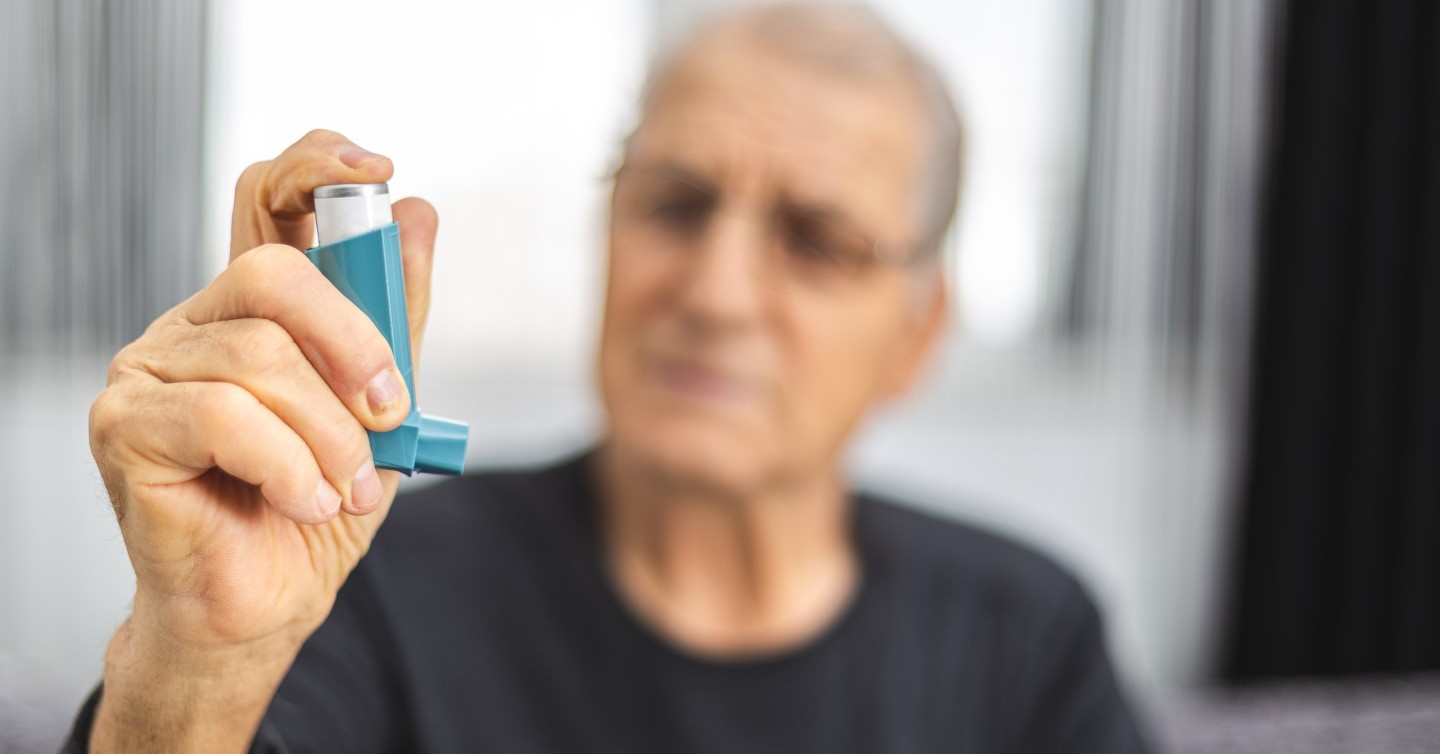 person with asthma holding asthma inhaler for attack